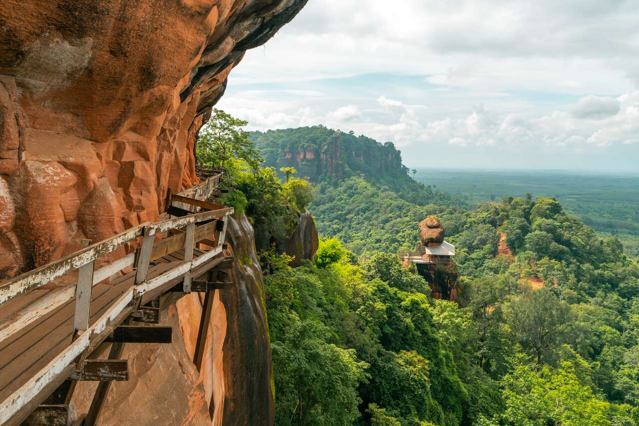A cliff face and view across lush jungle