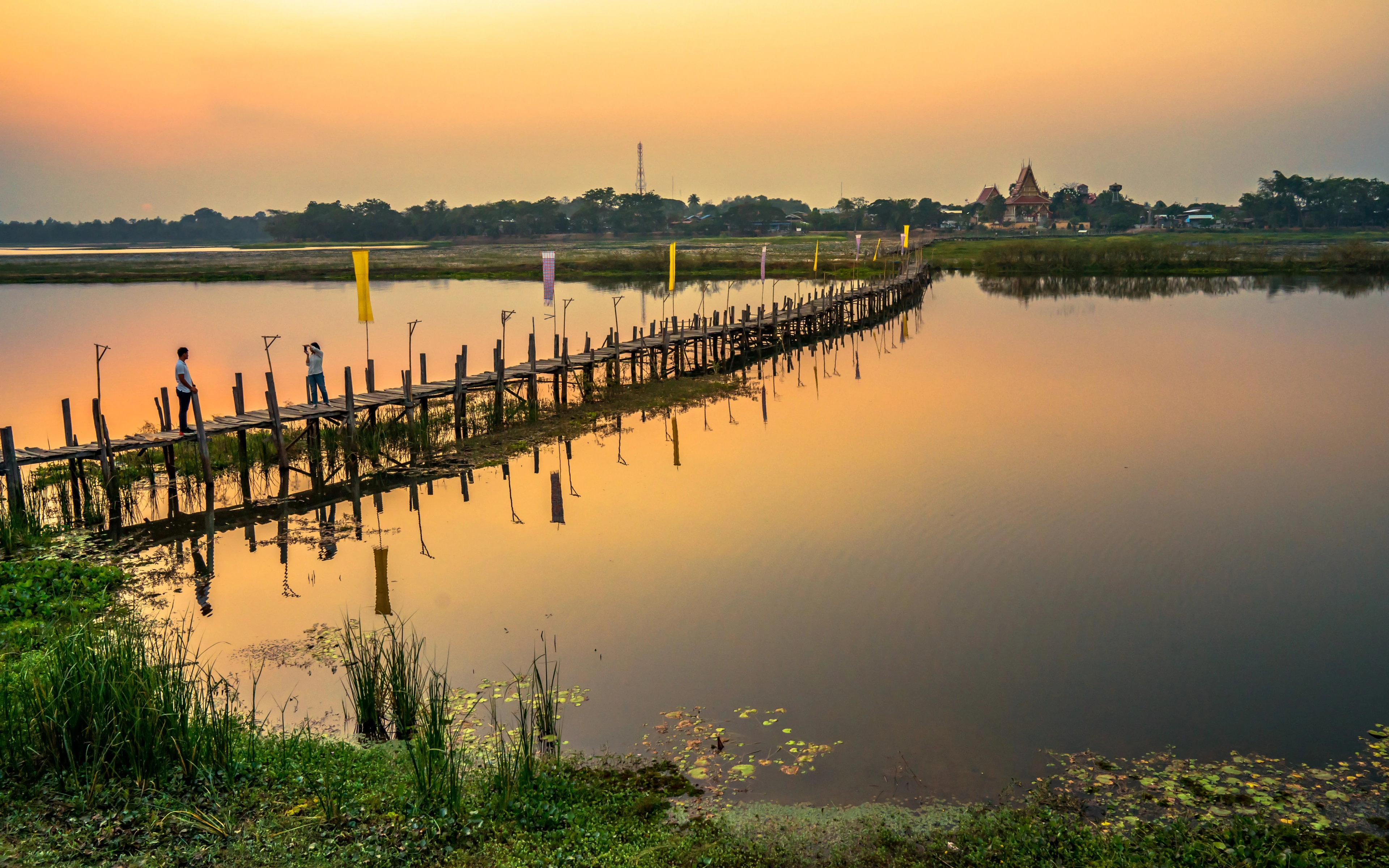 A photo of a beautiful Thai lake with a golden hue from the sun.