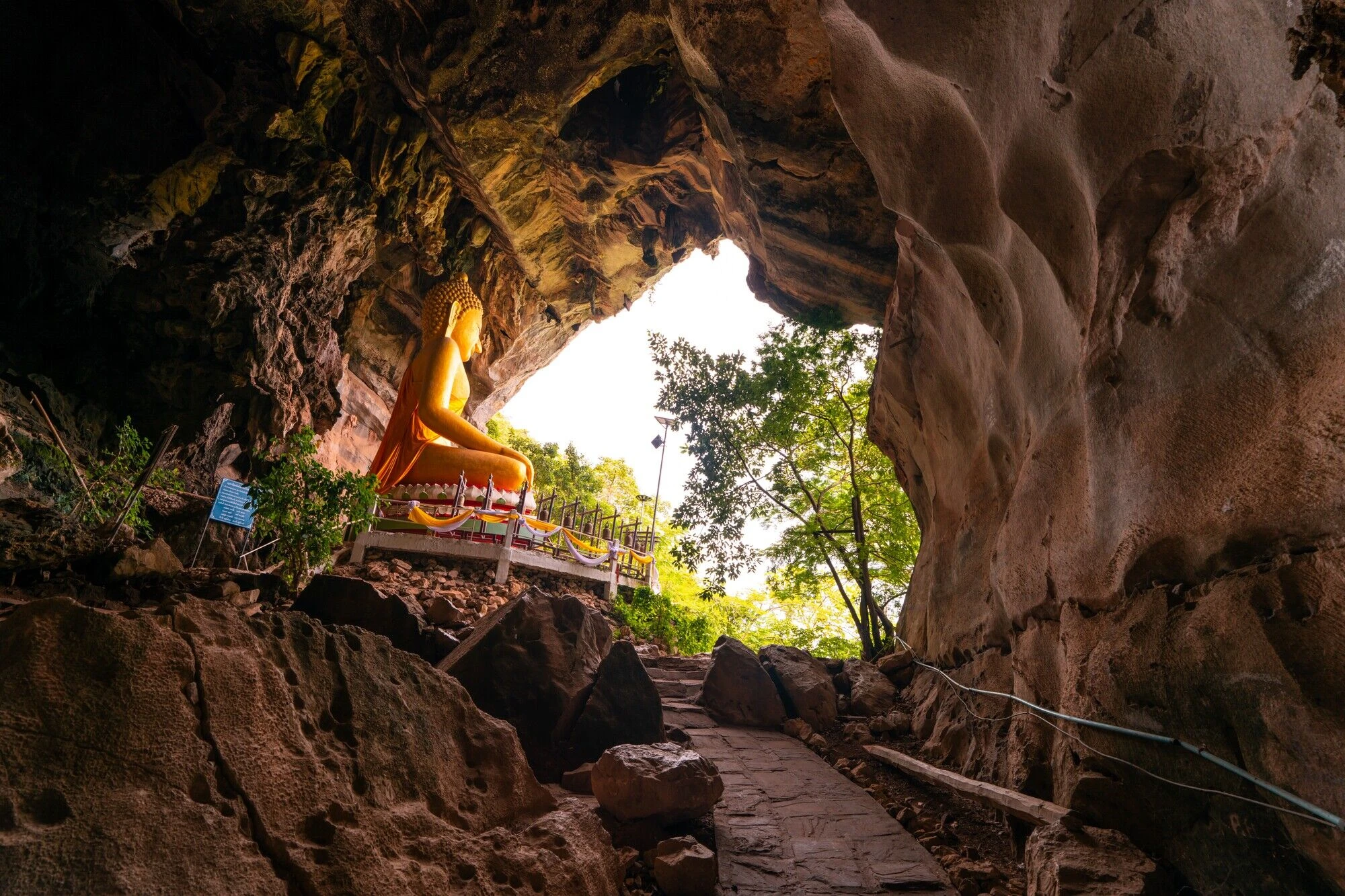 A golden Bhudda statue inside a cave.