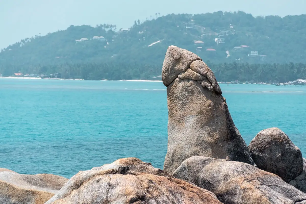 An unusual shaped rock against a background of turqoise waters